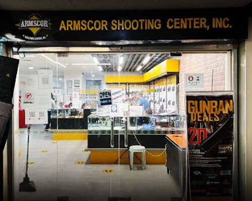 Ouside of Armscor Shooting Center, Inc.. 20% off gunban deals tarpauline and open sign hanging on the door